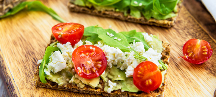Cracker mit Avocado, Ziegenkäse und Tomaten